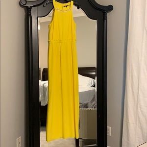 Women’s yellow maxi dress with gold trim.
